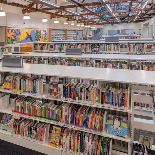 Interior of the new Northwest Library with books and artwork, links to library’s construction page.