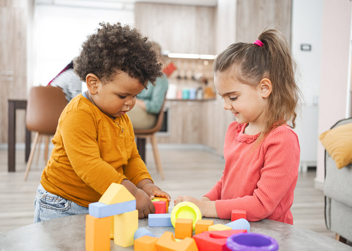Two young children play with blocks together.