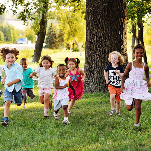Preschoolers running on grass outside, links to summer safety tips.